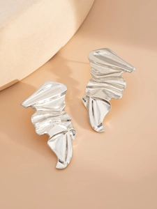 Detailed close-up of abstract silver irregular wave earrings with a polished metal finish