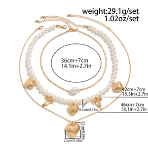 Detailed specs of gold layered necklace set with pearls, heart pendant, and bow detail