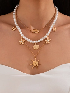 Close-up of layered ocean themed necklace with seashell, starfish and pearl charms