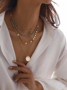 Détail d'un ensemble de colliers à 4 rangs avec perles bleues et pendentif doré