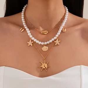 Three-layer ocean style necklace with gold shell pendants and white pearls on model