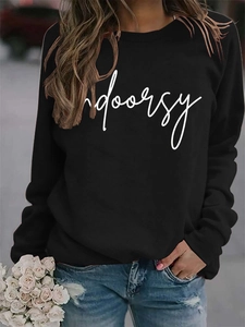Detail of black crewneck sweatshirt with white indoorsy print and ribbed cuffs