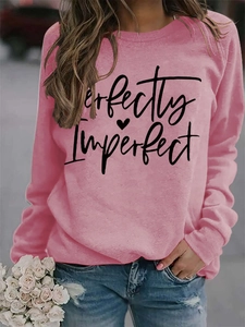 Close-up of pink crewneck sweatshirt with Perfectly Imperfect print and heart detail