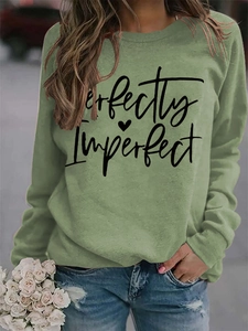 Detail of Perfectly Imperfect lettering and heart print on olive green sweatshirt
