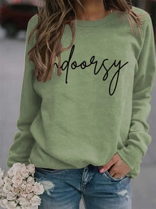 Detail of olive green crewneck sweatshirt with black Indoorsy script and soft cotton texture
