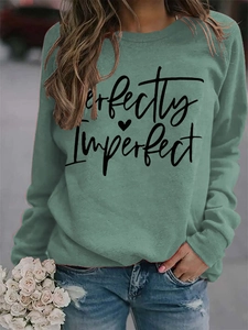 Detail of Perfectly Imperfect lettering on green long sleeve crewneck sweatshirt