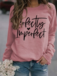 Close-up of Perfectly Imperfect print and heart motif on a pink sweatshirt for women