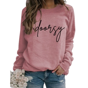 Detail of pink crewneck sweatshirt featuring black Indoorsy script print and soft knit fabric