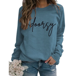 Detail of the blue crewneck sweatshirt with black indoorsy text and cotton fabric texture