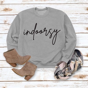 Flat lay of gray crewneck sweatshirt with indoorsy print, boots and scarf