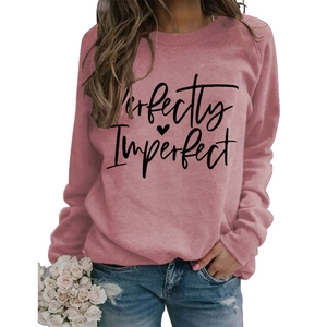Close-up of Perfectly Imperfect lettering and heart print on pink crewneck sweatshirt