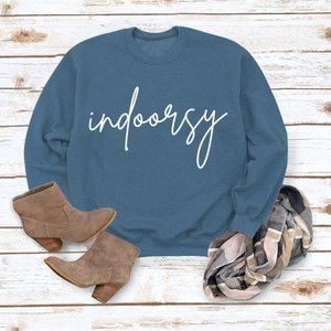 Flat lay of blue crewneck sweatshirt with indoorsy print and plaid scarf detail