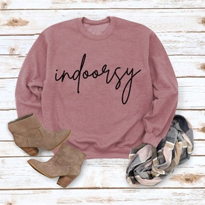 Detail of dusty rose crewneck sweatshirt with indoorsy print on wood background