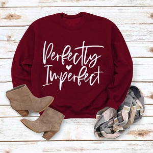 Flat lay of wine red Perfectly Imperfect sweatshirt with brown boots and plaid scarf