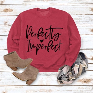 Flat lay of wine red Perfectly Imperfect sweatshirt with boots and a plaid scarf