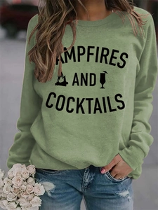 Close-up of Campfires and Cocktails graphic print on grass green crewneck sweatshirt