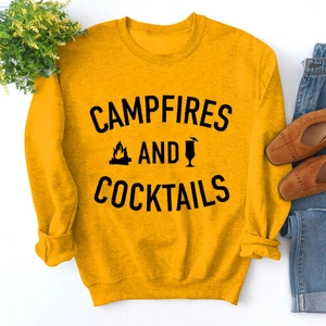 Flat lay of yellow sweatshirt with Campfires and Cocktails text and graphic details