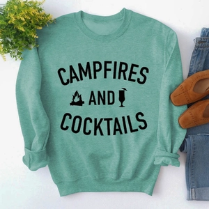 Flat lay of mint green long sleeve sweatshirt with Campfires and Cocktails graphic