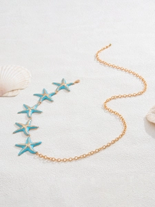 Close-up of gold chain with five blue starfish pendants on a white beach shell background