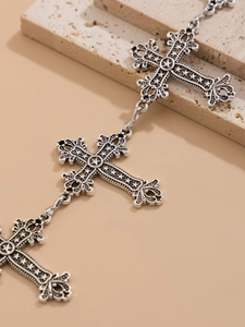 Détail d'une chaîne de taille gothique argentée avec croix ciselées et motifs d'étoiles