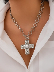 Detail of silver alloy cross pendant necklace with pearls and large chain links