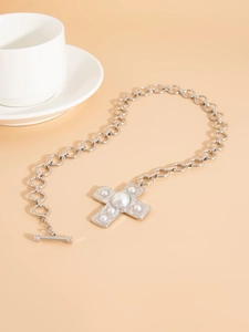 Close-up of vintage punk silver metal chain necklace with cross pendant and pearls