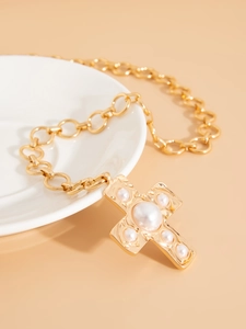 Close-up of gold chain necklace with a cross pendant featuring five white faux pearls