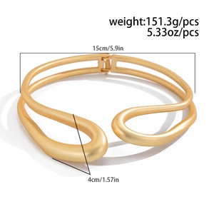 Gros plan d'un collier ras du cou en alliage doré mat avec un design torsadé à double couche