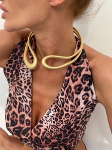 Détail d'un choker artistique en or mat avec design sculptural au style fluide