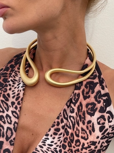 Vue détaillée du collier ras-du-cou sculptural en or mat sur le cou du mannequin