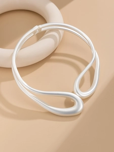 Détail du collier ras du cou argent mat au design minimaliste de goutte fluide
