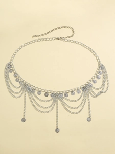 Détail de la chaîne de taille bohème argentée avec pendentifs pièces et franges