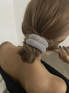 Élastique à cheveux double couche avec strass brillants porté sur un chignon bas