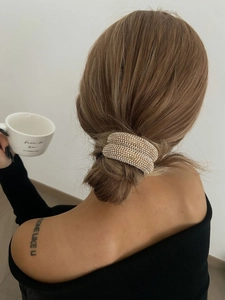 Gros plan sur accessoire de cheveux de luxe serti de strass porté sur un chignon
