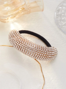 Détail macro d'un chouchou de luxe avec strass blancs sur base métallique dorée