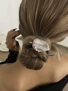 Détail de l'élastique feuille argentée avec strass sur chignon bas, vue arrière coiffure