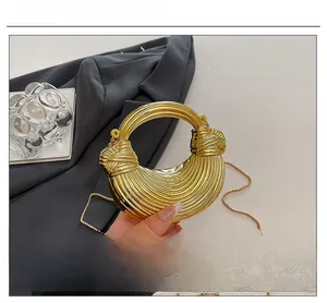 Detail der goldenen Halbmond-Tasche mit strukturierter Oberfläche und Ringgriff