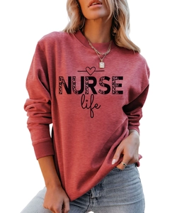 Close-up of the leopard print NURSE Life text on a coral red crewneck sweatshirt
