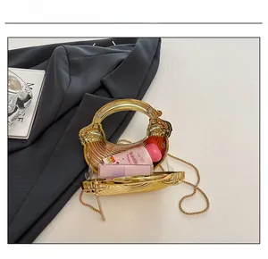 Innenansicht der goldenen Muschel-Abendtasche zeigt Platz für Handcreme und Kosmetika