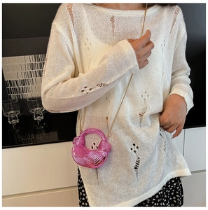 Nahaufnahme der metallic-pinken Tasche in Halbmondform mit goldenem Kettengurt