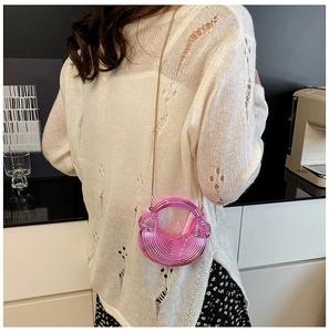Nahaufnahme der hellrosa Halbmond-Tasche mit Muschelstruktur und goldener Kette