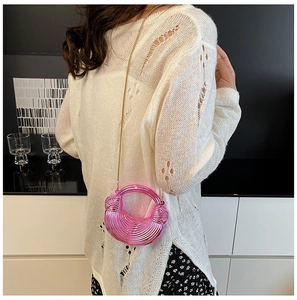 Detail der metallisch rosa Halbmond-Handtasche mit Rippenstruktur und gewebten Knoten