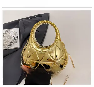Détail du sac géométrique doré avec finition métallique et poignée supérieure ronde