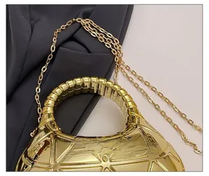 Détail du sac croissant doré avec surpiqûres géométriques et bandoulière en chaîne