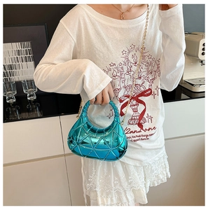 Détail du sac métallisé bleu vif avec surpiqûres triangulaires et chaîne dorée chic
