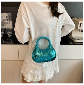 Détail d'un sac à main bleu électrique à motifs géométriques et fine chaîne dorée