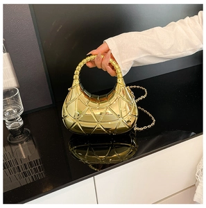 Vue détaillée du motif géométrique et de la poignée perlée du sac doré chic