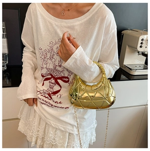Détail du sac demi-lune doré avec matelassage géométrique et finition métallique brillante