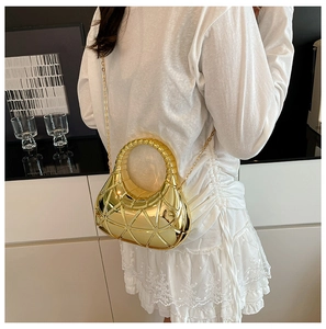 Détail d'un sac à main géométrique doré avec motif triangulaire et finition miroir chic