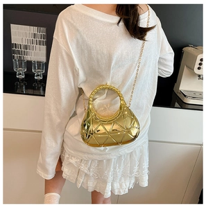 Mannequin portant un sac bandoulière doré métallisé avec chaîne et motifs géométriques